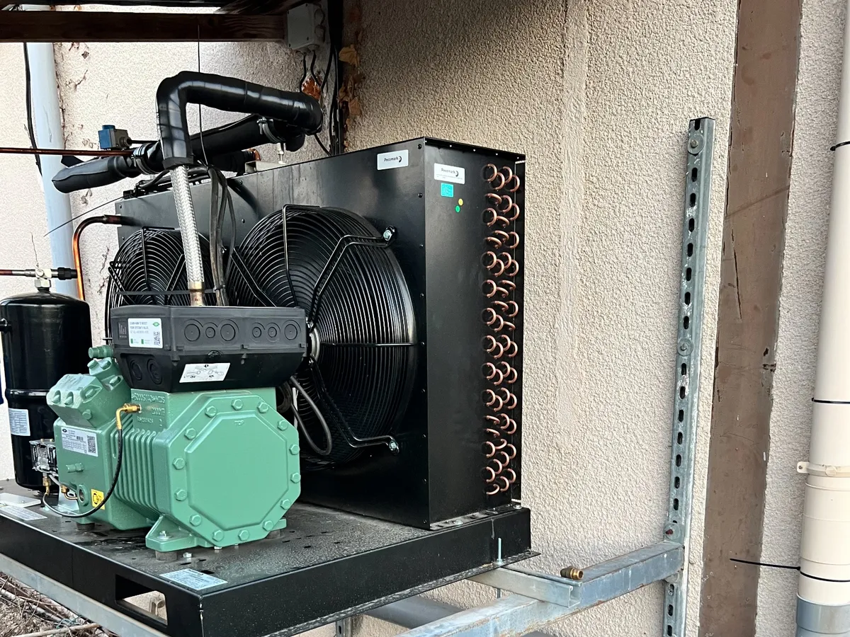 Groupe de condensation extérieur en cours de dépannage : compresseur, ventilateur et condenseur