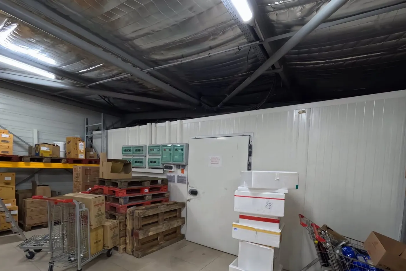 Entrepôt logistique isolé en panneaux sandwich, marchandises sur palettes