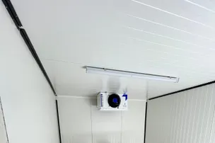 Évaporateur plafonnier en fonctionnement dans une chambre froide en panneaux blancs